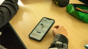 Hände, Federpenal und Handy